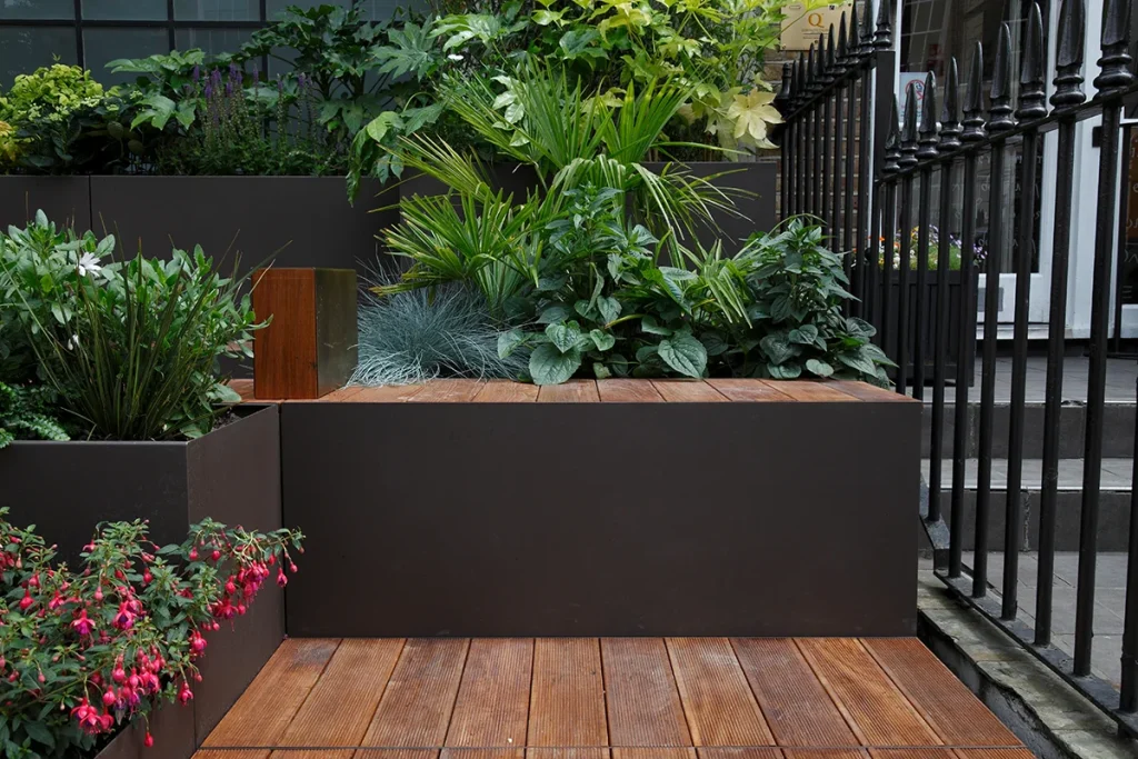 A modern garden with a wooden deck and plants.