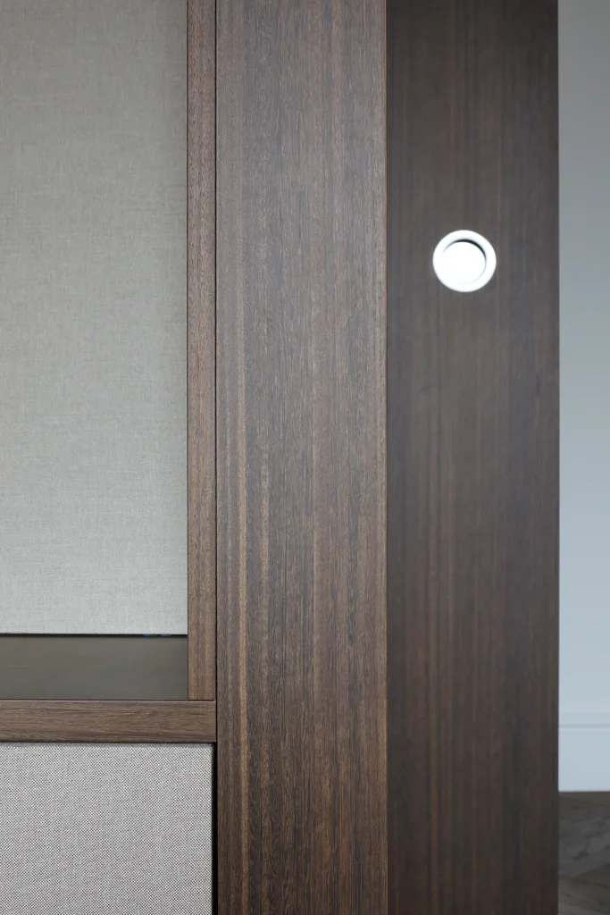 Close-up of a wooden partition with a single round white push light embedded in it, showcasing sleek design against a light gray background. Map Projects