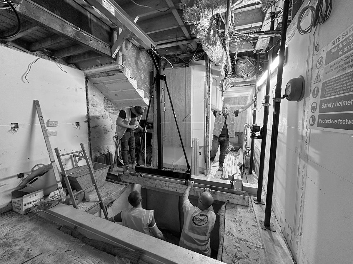 Construction underway inside the central stairwell, with temporary supports and scaffolding around lift shaft
