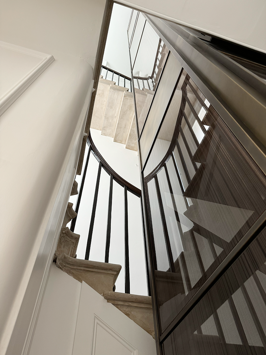 View from below showing the new glass lift shaft rising through the original Portland stone staircase