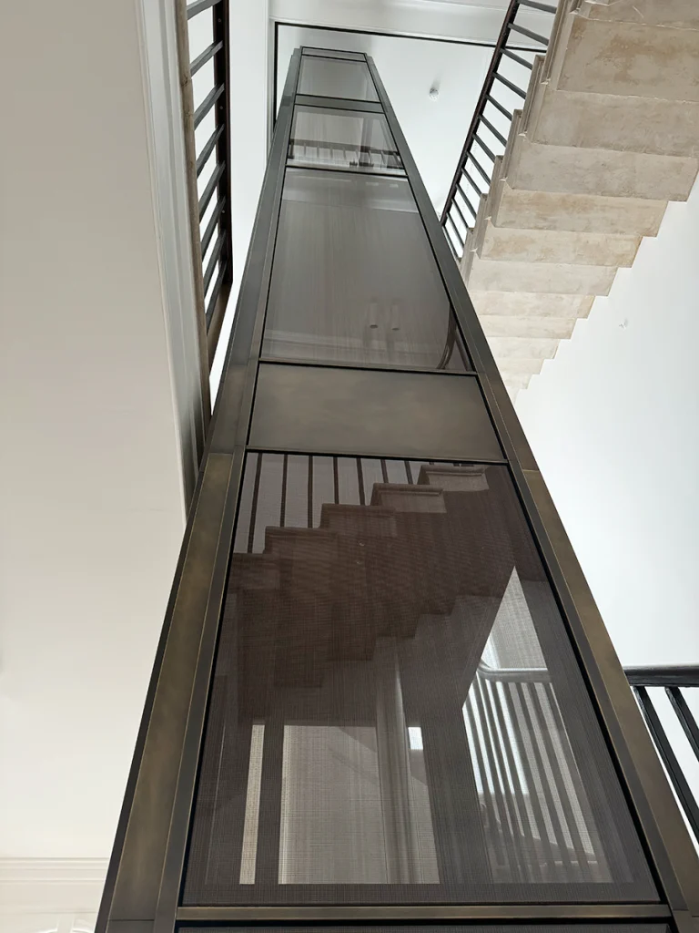 Looking up through the finished glass lift shaft with soft natural light
