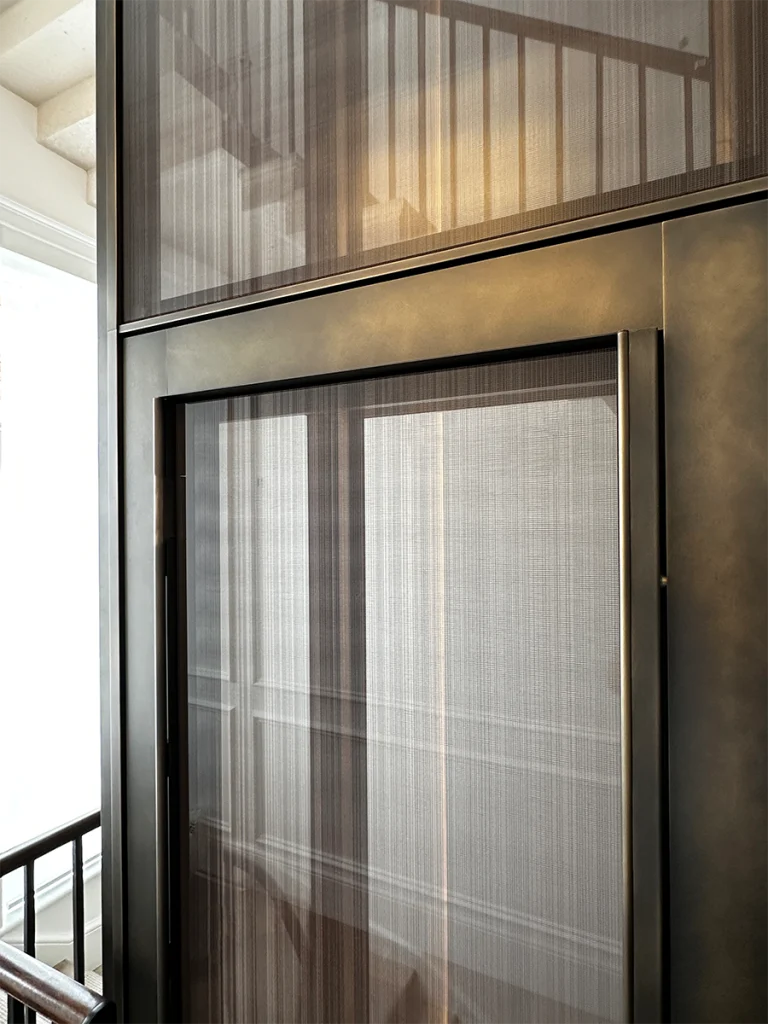 Completed lift shaft glowing under warm interior lighting during evening hours