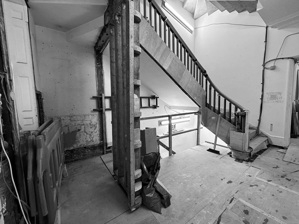 Black-and-white image of original stairwell shaft pre-lift installation