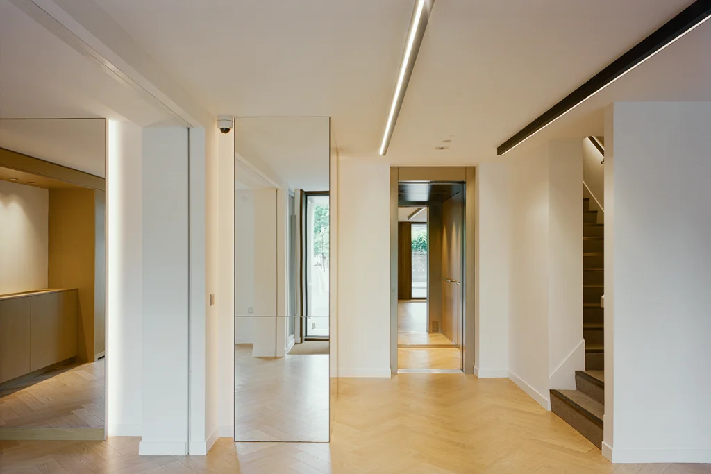 Open-plan hallway with recessed ceiling lighting and wood flooring