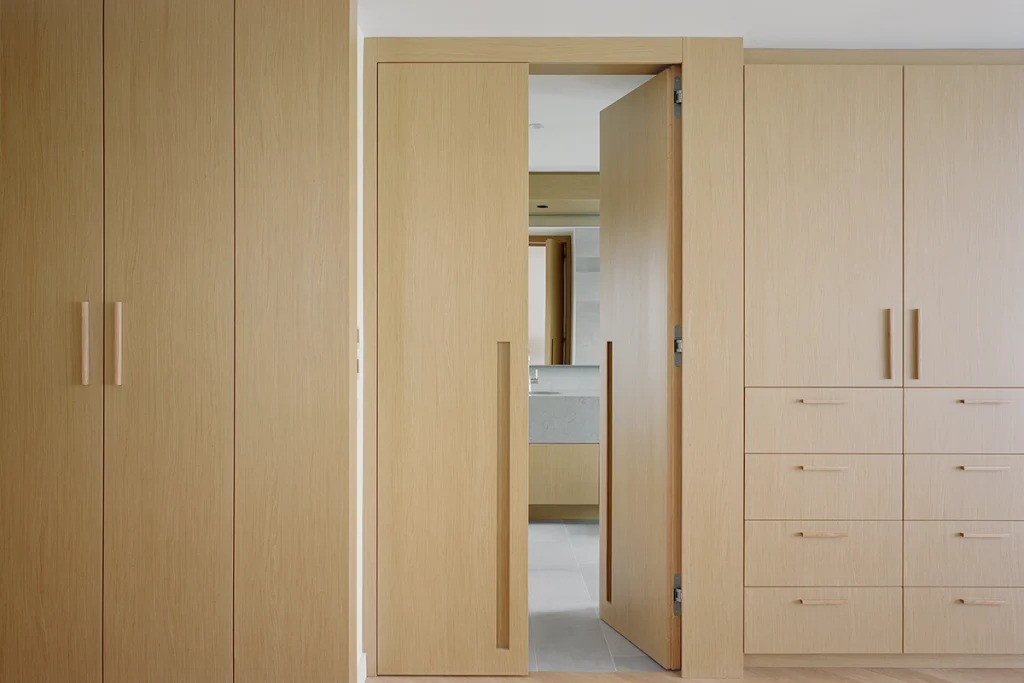 Fitted wooden cabinetry with built-in wardrobes and drawers
