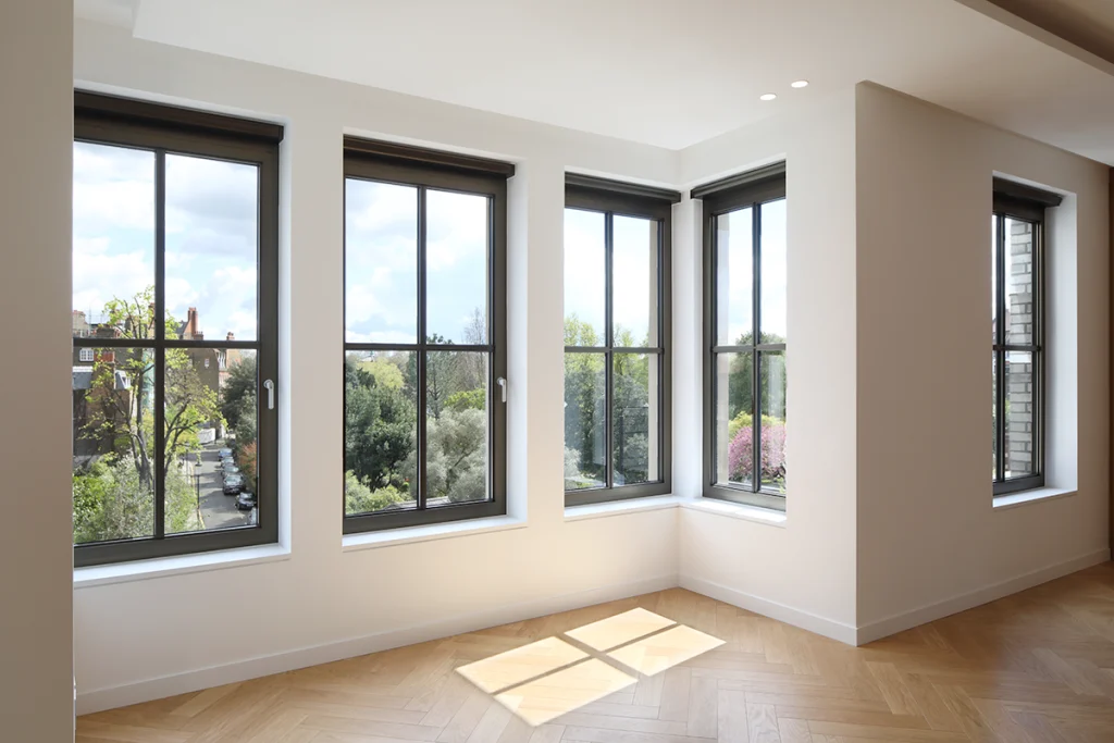 Interior living area with corner windows and wooden flooring, flooded with natural light