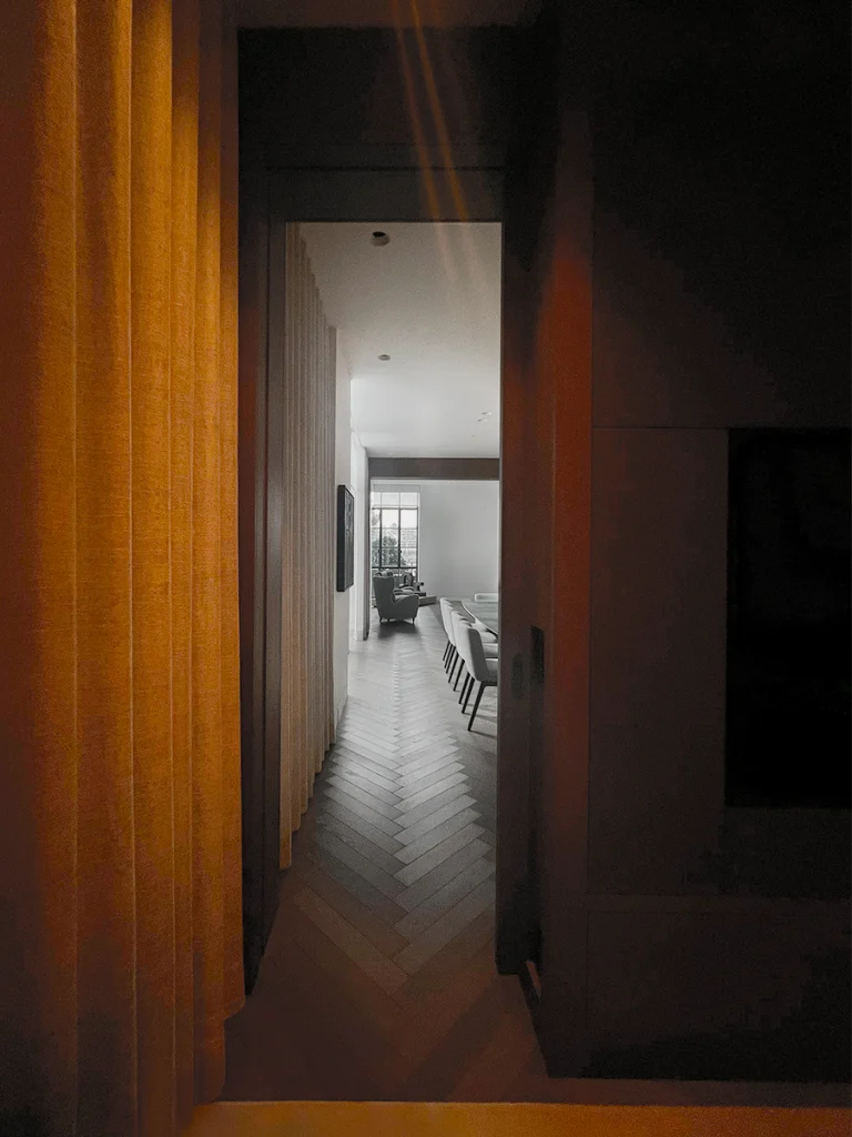 Dimly lit corridor revealing golden-toned timber cladding and doorway