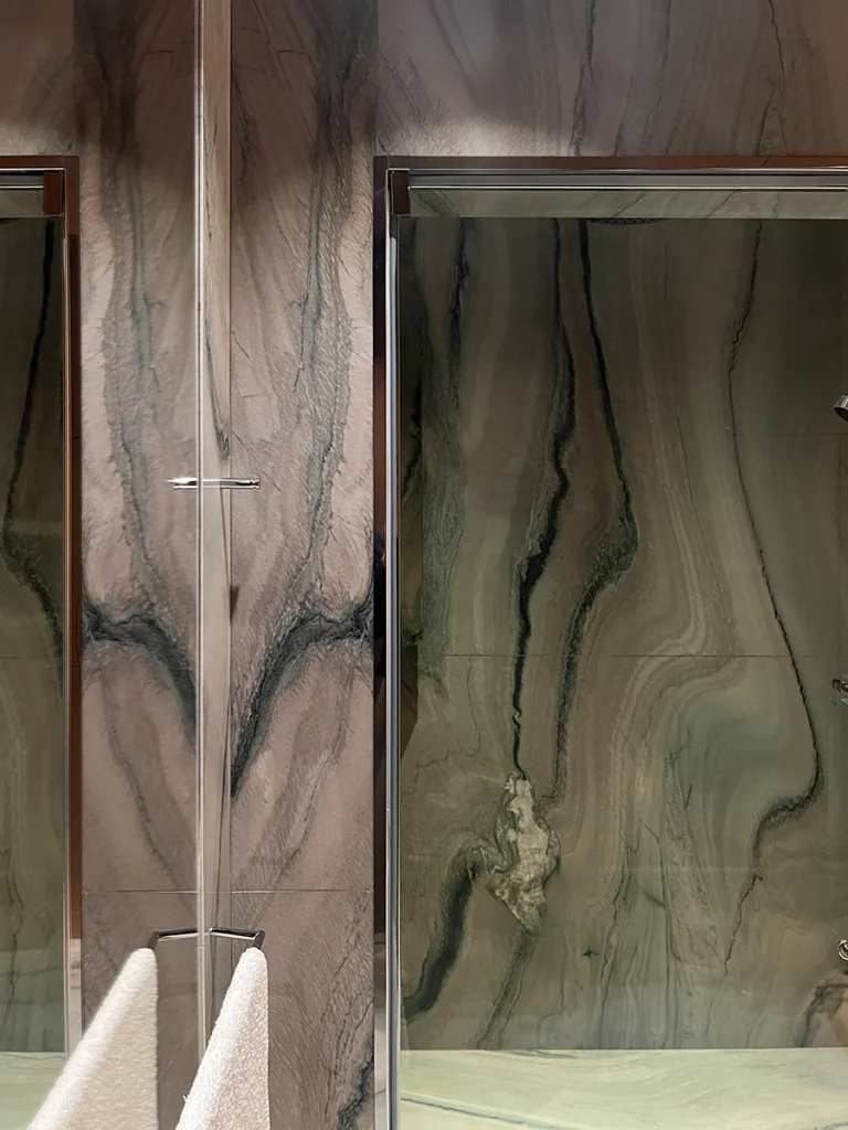 shower with glass and textured green-veined marble