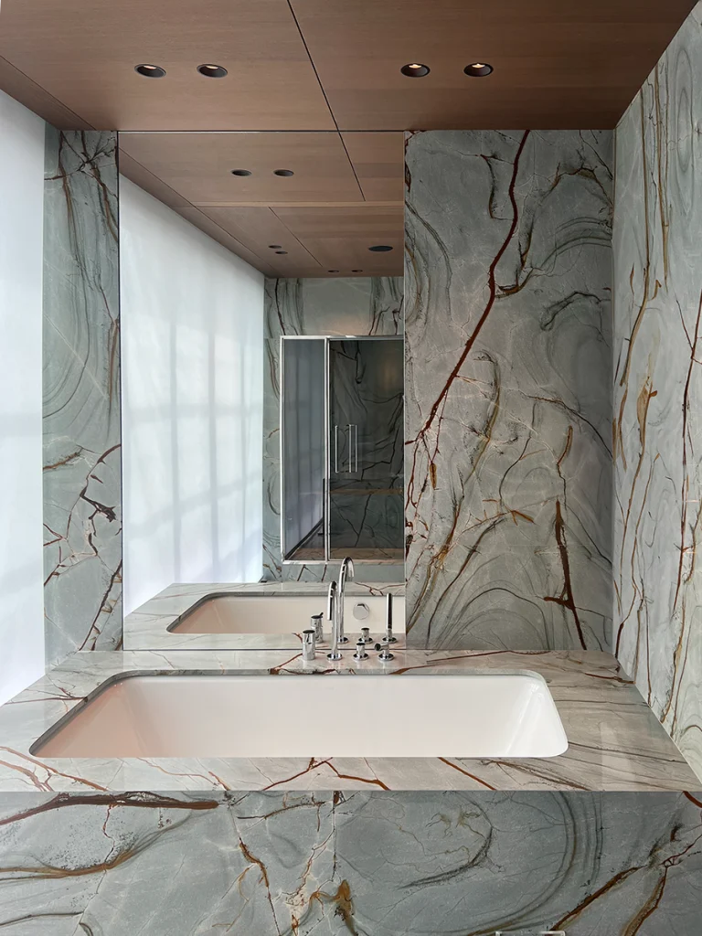 marble panelled walls and built-in sink and mirror