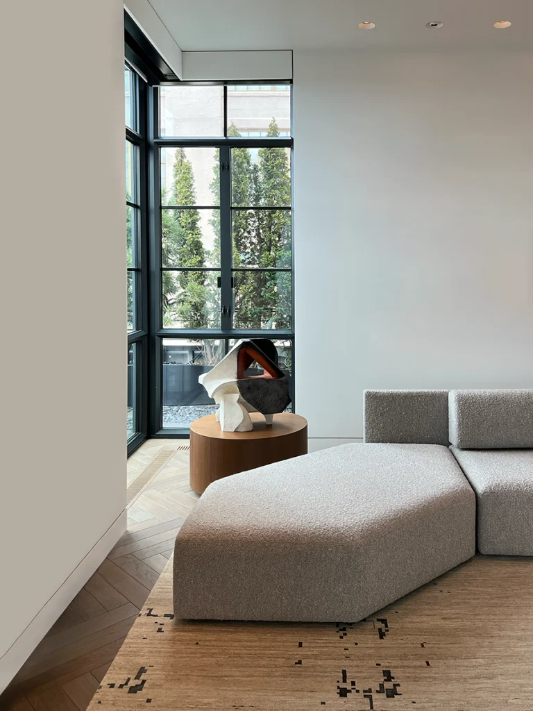 Lounge area with modular sofa, gallery-white walls, and glazed doors to terrace