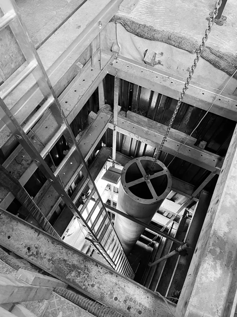 Black-and-white construction image showing lift shaft installation