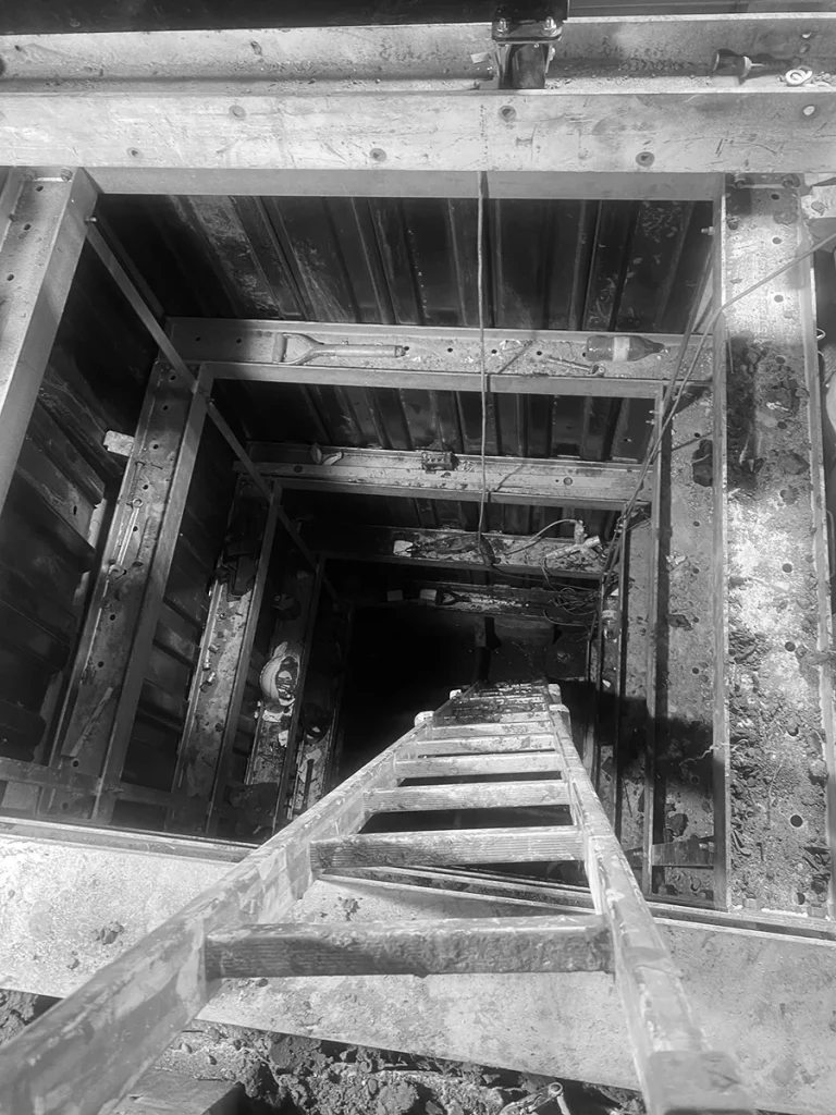 Black-and-white image of original stairwell shaft pre-lift installation